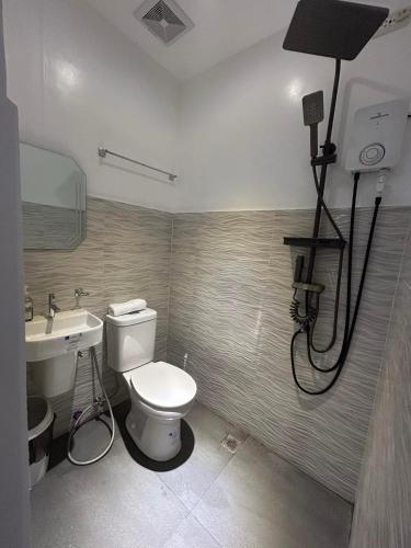 a bathroom with a toilet and a sink at Tim's Guest House in Butuan