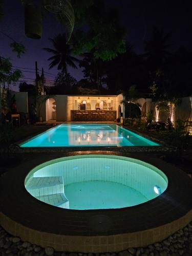 a swimming pool in a yard at night at Casa Carmen Hostel in Weligama