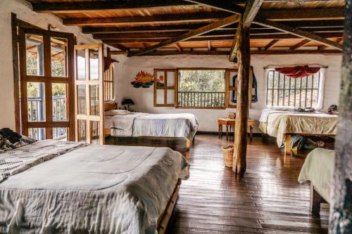 a bedroom with two beds in a room with windows at Hostel Casa de Nelly in San Agustín