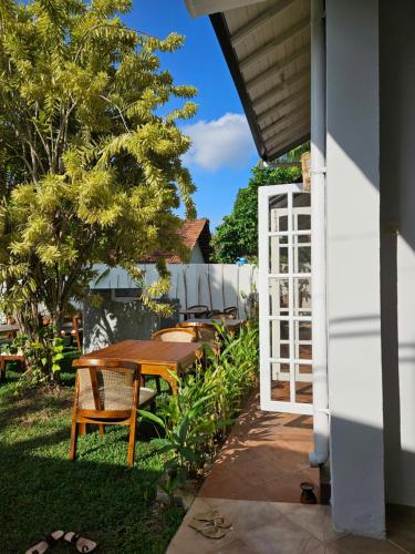 a patio with a table and chairs and a white door at Casa Carmen Hostel in Weligama