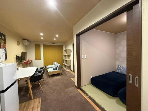 um quarto com uma cama, uma secretária e uma cozinha em Vieuno Hida Takayama em Takayama