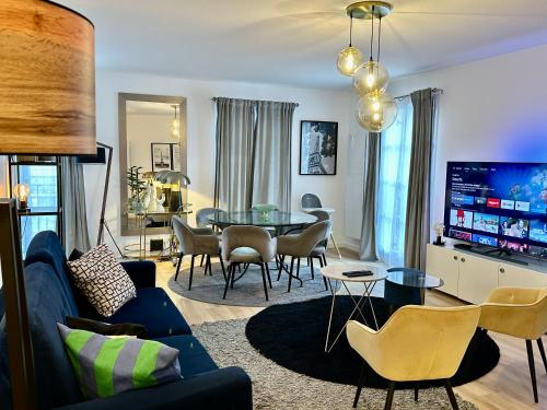 a living room with a blue couch and a table at Apt Place de Toscane - 4min Disneyland-PARIS in Serris