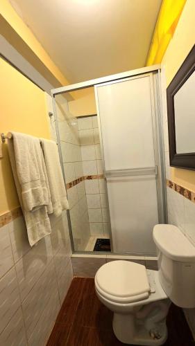 a bathroom with a white toilet and a shower at Hospedaje plaza inn in Nauta