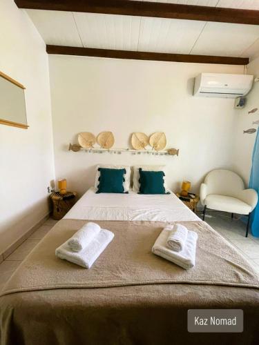 a bedroom with a bed with towels on it at Gîtes Kaz Tchò in Sainte-Anne