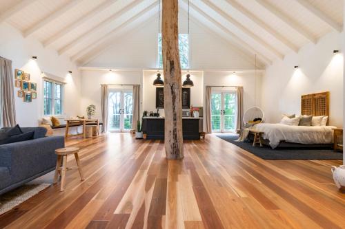 een grote woonkamer met een bed en een bank bij The Red Hill Barn in Main Ridge