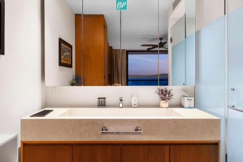 a bathroom with a sink and a large mirror at Zantamar - Beachfront Suites in La Cruz in Cruz de Huanacaxtle