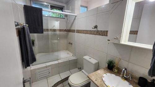 Duplex com Hidro em Condomínio Luxo com 3 Praias في انغرا دوس ريس: حمام مع حوض استحمام ومرحاض ومغسلة