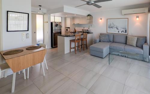 Una sala de estar y una cocina con un sofá y una mesa. en Noosa Parade Holiday Inn, en Noosa Heads