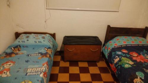 a bedroom with two twin beds and a checkered floor at Casa cerca de la playa in La Paloma