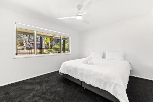 Poppi's Paradise - 5 Minutes Walk to the Beach في سانكشوري بوينت: غرفة نوم بيضاء مع سرير ونافذة