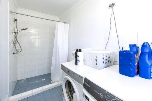 Poppi's Paradise - 5 Minutes Walk to the Beach في سانكشوري بوينت: وجود غسالة في الحمام مع دش