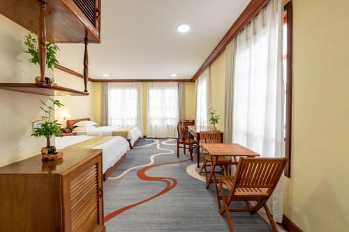 Domi Hotel في سيام ريب: غرفة فندق بها سرير وطاولة وكراسي