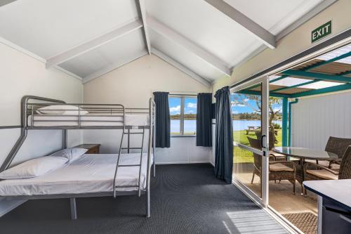 a room with two bunk beds and a table at Waitangi Holiday Park in Paihia
