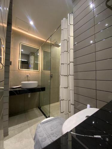 a bathroom with a sink and a glass shower at MBS HOTEL Medan in Medan
