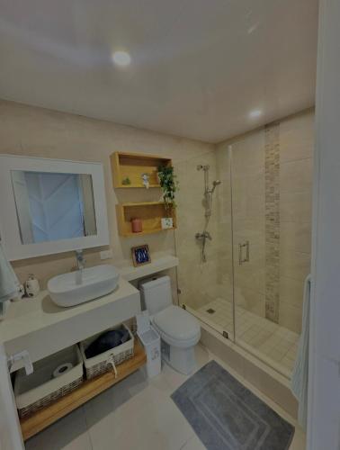 a bathroom with a toilet and a sink and a shower at Las Olas Apartment, Juan Dolio in Guayacanes