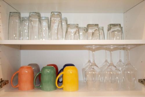 a bunch of glasses sitting on a shelf at Studio - Cozy Downtown Hideaway in Sudbury