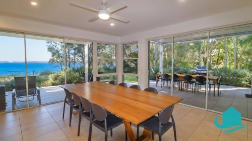 a dining room with a table and chairs at Pelican Escape Executive Home in Cams Wharf