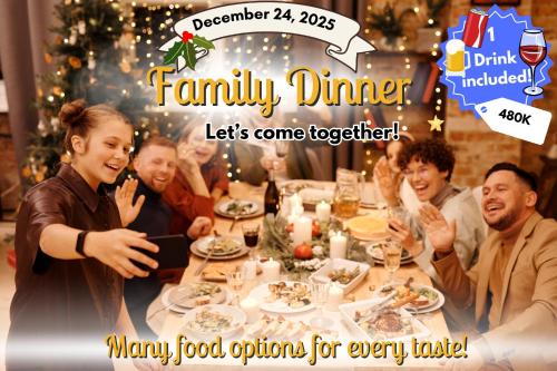 a group of people sitting around a table eating food at Nalani Homestay & Hostel Hoi An in Hoi An