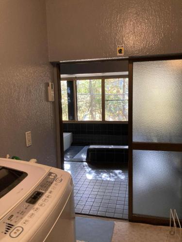 a kitchen with a stove and a door to a room at Forest View Guesthouse in Omachi