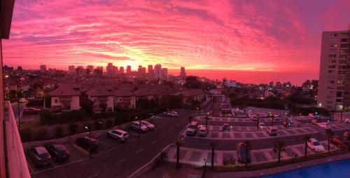 una ciudad con coches estacionados en un estacionamiento al atardecer en Descanso y Comodidad absoluta en el mejor sector, en Concón