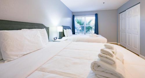 a bedroom with two white beds and a window at Disney Universal Family Resort # Pool # Gym in Orlando