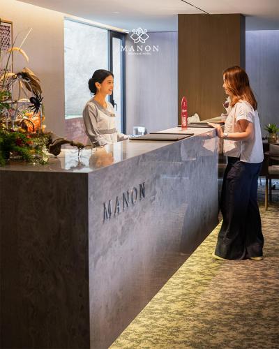 two women standing at a counter in an office at Manon Boutique Hotel Kota Lama Semarang in Semarang