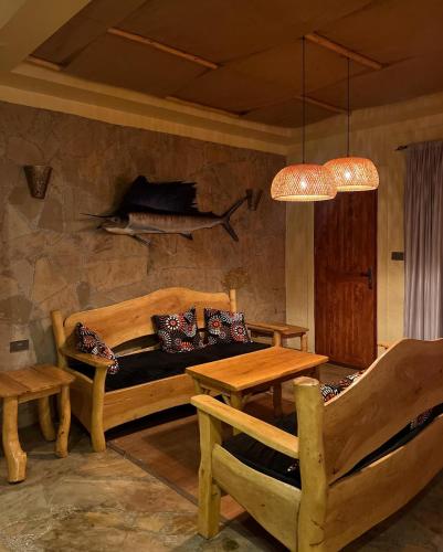 Vota Ranch Luxury Villa Stay & Nature Retreat في Machakos: غرفة نوم بها سرير وطاولة وسمكة على الحائط