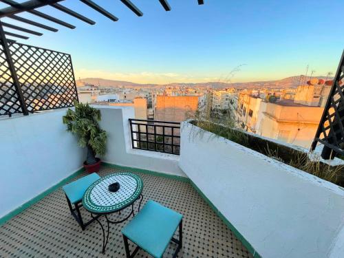 a balcony with a table and chairs and a view at Hotel Nouzha in Fez