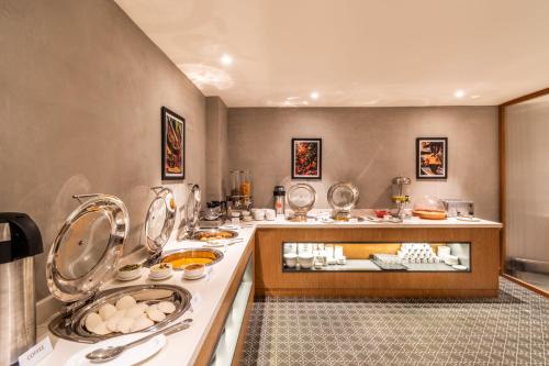 a room with a counter with food on it at Hotel Vaari Vista By Bestinn Leisure in Bengaluru