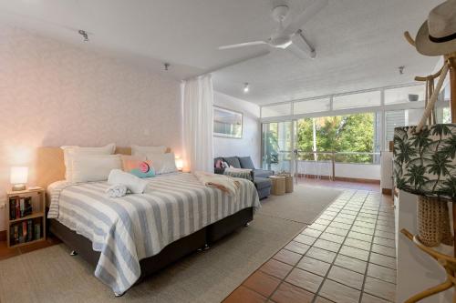 Studio on Macrossan في ميناء دوغلاس: غرفة نوم بها سرير كبير وغرفة معيشة