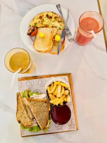 a table with a plate of food with a sandwich and french fries at Elysium Tower Premium Serviced Apartments Facing Centaurus Mall Islamabad in Islamabad