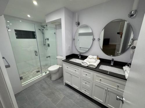 a bathroom with a shower and a sink and mirror at Beachfront two story apartment in Miami Beach