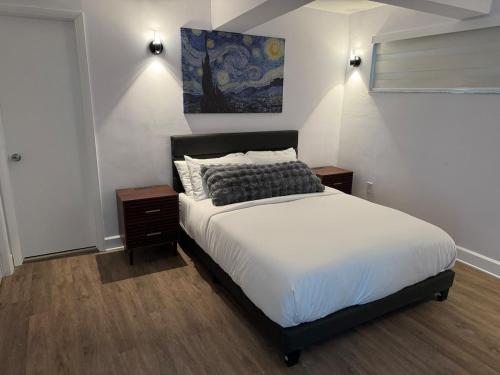 a bedroom with a bed and a painting on the wall at Beachfront two story apartment in Miami Beach