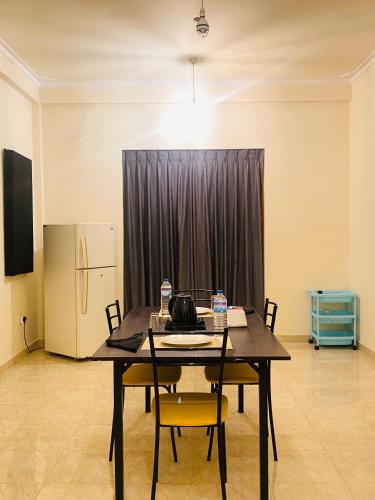 a dining room with a table with chairs and a refrigerator at DropHaus in Naula