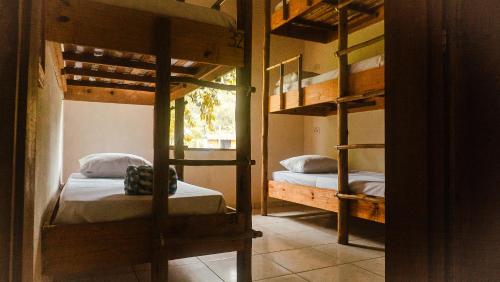 a room with two bunk beds and a doorway at Drop House Hostel in Ubatuba