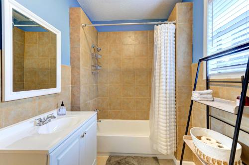 a bathroom with a bath tub and a sink at Spacious 3BR Midtown Home - Sleeps 7 - Walkable to Dining & Attractions - Easy Access to Downtown in Memphis