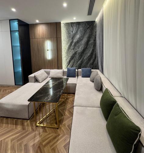ein Wohnzimmer mit Sofa und Tisch in der Unterkunft Modern 1BR, Lux-Skyscraper Large, Loggia and View in Taschkent