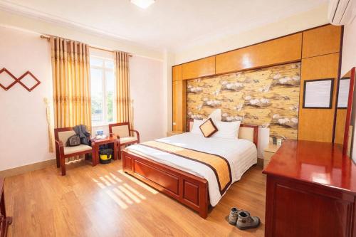 a hotel room with a bed and a desk at Hải Vân Hotel Điện Biên in Diện Biên Phủ