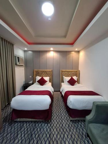 a hotel room with two beds and a couch at اصداء الراحة للشقق المخدومة 3 in Riyadh