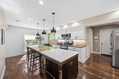 Stay at this Old Fashion House in Bardstown في باردستاون: مطبخ بدولاب بيضاء وجزيرة كبيرة