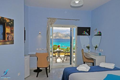 a hotel room with a bedroom with a view of the ocean at Myrto Hotel in Koufonisia