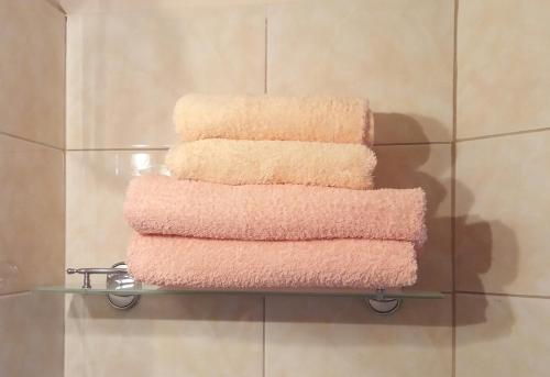 una pila de toallas en una estantería de cristal en el baño en Guesthouse on Zygina Street, en Polatsk