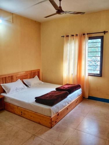 a bedroom with a wooden bed with a window at Ivan homestay in Kulu