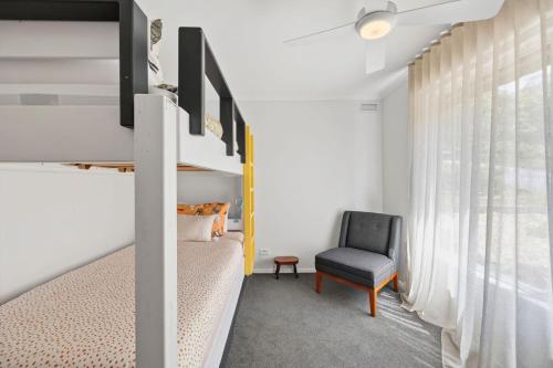 una camera da letto con un letto a castello e una sedia di Annelise a Lorne