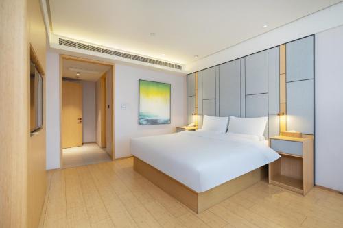 Ένα ή περισσότερα κρεβάτια σε δωμάτιο στο JI Hotel Shanghai Jiuting Center
