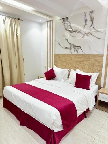 الجوهرة بارك 4 للشقق المخدومة في حفر الباطن: غرفة نوم بسرير كبير مع وسائد حمراء وبيضاء