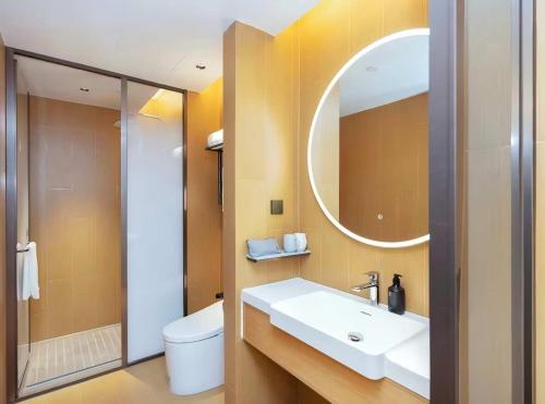 een badkamer met een wastafel en een spiegel en een toilet bij JI Hotel Suzhou Dushu Lake Ecological Park in Suzhou