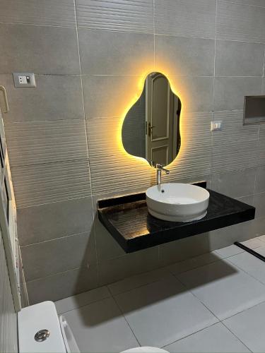 Almajidy Villa في القاهرة: حمام مع حوض ومرآة على الحائط