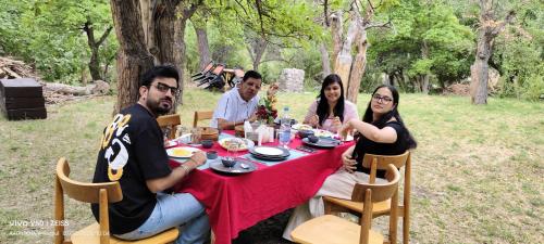 Saspul GömpaMoljoks Heritage House的一群坐在野餐桌上的人