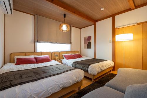 a bedroom with two beds and a chair at casa de tsuru in Osaka